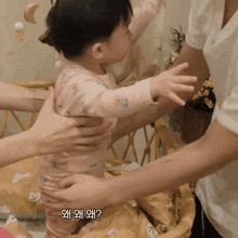 a baby is being held by a woman with korean writing on her arm