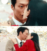 a man in a suit and tie kisses a woman in a red jacket