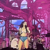 a woman in a bikini singing into a microphone