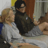 a man and a woman are sitting on a couch with a bottle of soda in front of them