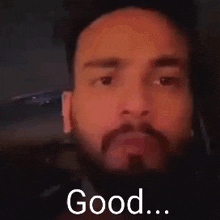 a man with a beard is giving a thumbs up sign with his hands .