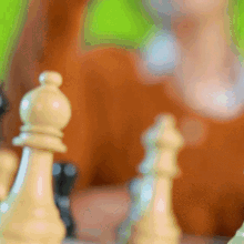 a person is playing a game of chess with pieces on a table