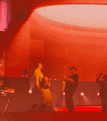 a man playing a guitar and a man singing on a stage