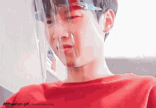 a gif of a boy wearing a face shield and a red shirt