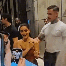 a man and a woman are standing next to each other in an elevator . the woman is wearing a red dress .