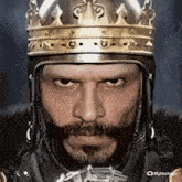 a man with a beard wearing a helmet and a crown