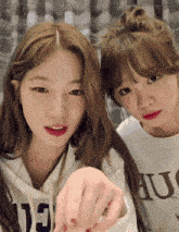 two girls are standing next to each other and one has a shirt that says hu on it