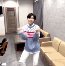 a young man is dancing in a living room with a couch and chairs .