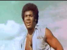 a man without a shirt is dancing in front of a blue sky .