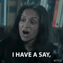 a woman says " i have a say " in front of a book shelf