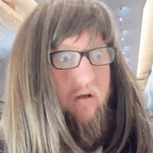 a man wearing glasses and a wig looks surprised