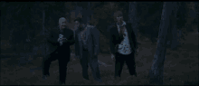 a man in a suit and tie is walking through the woods at night .