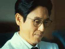 a close up of a man wearing glasses and a white shirt and tie