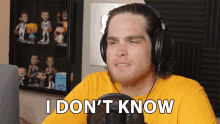 a man wearing headphones says " i don 't know " in front of a microphone