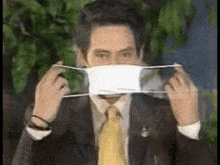 a man in a suit and tie is wearing a face mask