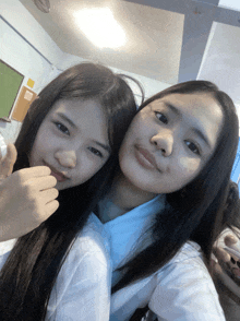 two girls are posing for a picture and one is giving the thumbs up sign