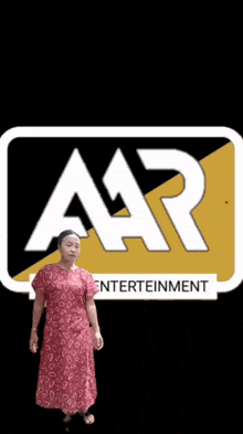a woman in a red dress stands in front of a logo for aar entertainment