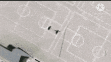 an aerial view of a school building with a basketball court drawn on the ground .