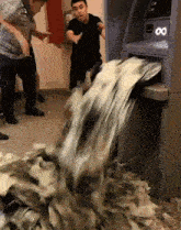 a man is standing in front of an atm machine that has the number 8 on it