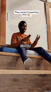 a man sits on a ledge looking at his phone with a caption that says they weren 't expecting that