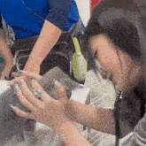 a woman with long nails is holding a small animal