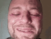 a close up of a man 's face with tears coming out of his eyes