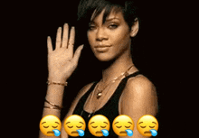 a woman in a black tank top is waving her hand in front of a row of crying emojis .