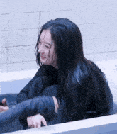 a woman with wet hair is sitting in a bath tub