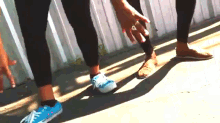 a person wearing a pair of blue converse shoes is standing next to another person wearing brown shoes