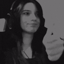 a black and white photo of a woman wearing headphones and smiling