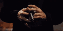 a close up of a person holding a stack of playing cards .