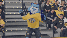 a mascot for the nashville predators stands in front of a crowd of fans