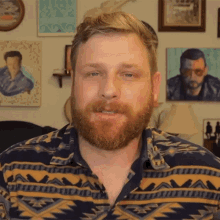 a man with a beard is wearing a shirt with a geometric pattern