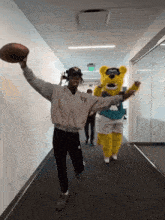 a man in a y3 jacket holds a football in his hand