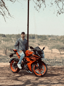 a man sits on an orange and black motorcycle with a license plate that says ktm rc390