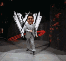 a man in a suit and tie is dancing on a stage in front of a wwe logo