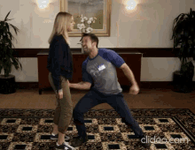 a man with a name tag on his shirt is dancing with a girl
