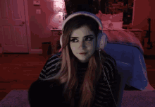 a girl wearing headphones looks at the camera