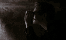 a man in a dark room is holding a flashlight in his hand