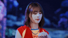 a girl wearing a red and yellow shirt that says sul on it