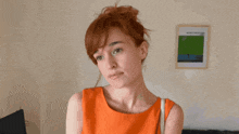 a woman in an orange dress stands in front of a framed picture that says ' afternoon ' on it