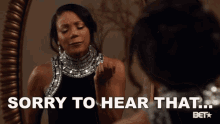 a woman is looking at herself in a mirror and says sorry to hear that .