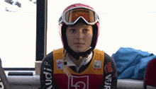 a woman wearing a helmet and goggles has an audi logo on her sleeve