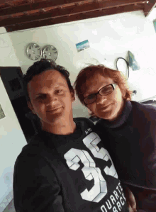 a man wearing a black shirt with the number 35 on it stands next to a woman