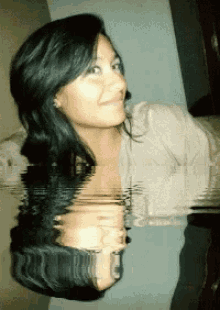 a woman 's face is reflected in the water