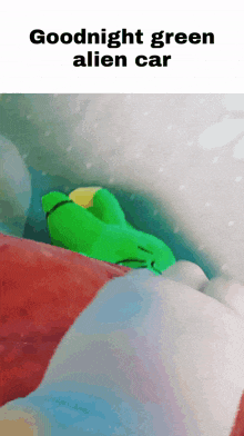a green stuffed animal is sleeping in a bed with the words " goodnight green alien car " above it