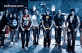a group of young men are standing next to each other on a street in a dark room .