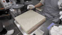 a person in a striped apron is working on a machine with the words made in animatica on the bottom right