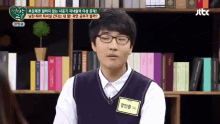 a man wearing glasses and a name tag that says jtbc