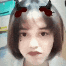 a close up of a woman 's face with horns on her hair